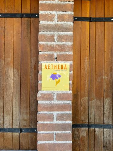 a sign on a brick wall next to a wooden fence at Aethera in Revine Lago