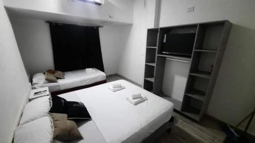 een kleine kamer met een bank en een tv bij Solano House in Termas de Río Hondo