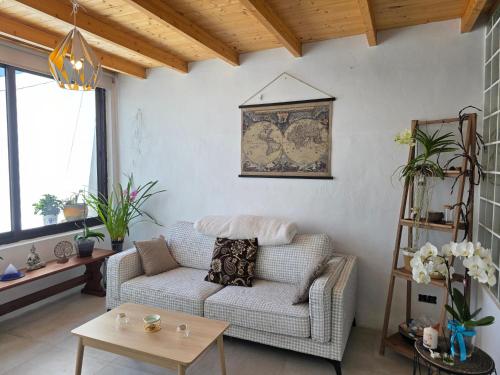 a living room with a couch and a table at Alunita & Pirita, Habitación con Jardín, Terraza y WiFi en zona tranquila y céntrica in Nazaret