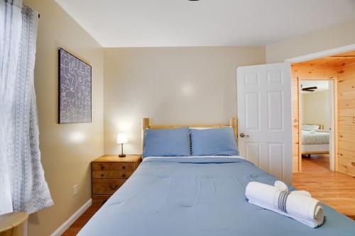 a bedroom with a large blue bed with blue pillows at Modern 6BR Cabin- Hot Tub Theater Basketball in White Haven