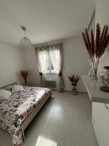 a bedroom with a bed and a table and a window at Havre de paix dans un joli petit coin de verdure in Saint-Sulpice-le-Guérétois
