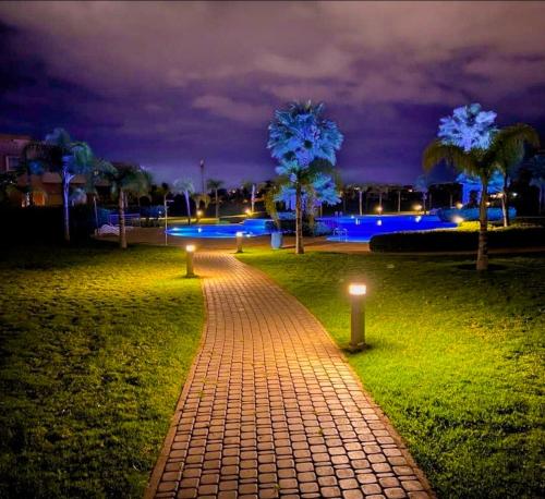 een bakstenen pad met verlichting in een park 's nachts bij Privilege house Opale in Marrakesh