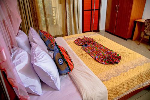 a bed with two ties sitting on top of it at Good News Hotel in Kigali
