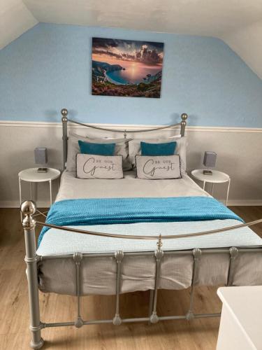 a bedroom with a bed with a blue wall at Braemar in Weymouth