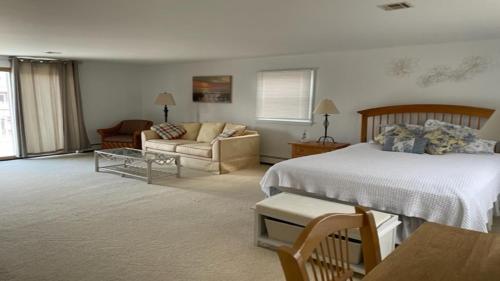 ein Wohnzimmer mit einem Bett und einer Couch in der Unterkunft Beach Badges, Wifi, Private Yard, Washer Dryer, Roomy Cape Located Bayside In Long Beach Island New Jersey in Ship Bottom