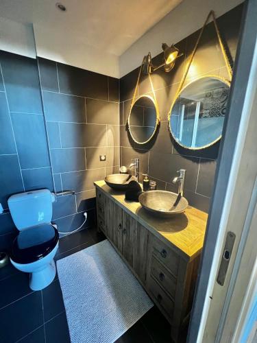 une salle de bain avec deux lavabos et un WC et des miroirs dans l'établissement Triplex Port de Bénodet, à Bénodet