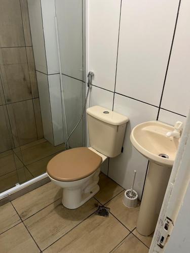 a bathroom with a toilet and a sink at Casa para 9 pessoas perto da Dom Pedro 2 in Porto Alegre