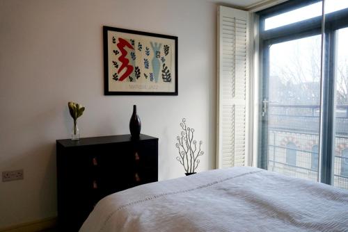 a bedroom with a white bed and a window at Cally Flat in London