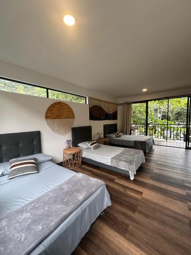 a bedroom with two beds and a balcony at Hotel Rossé in La Vega