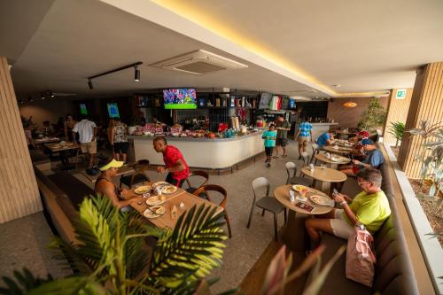 a group of people sitting at tables in a restaurant at Dreamer Beach Club in San Andrés