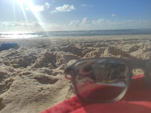 une paire de lunettes de soleil assise dans le sable sur la plage dans l'établissement lesmobilhomesduferret - camping Les Embruns - mobil-homes de particuliers, funpass activités non inclus, à Lège-Cap-Ferret