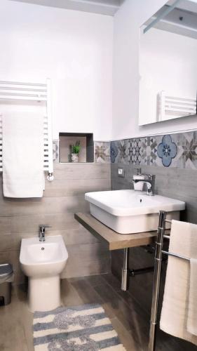 a bathroom with a white sink and a toilet at Tourist House Palermo in Palermo