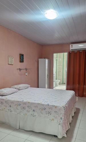 a bedroom with a bed and a refrigerator in it at Aconchego da Marci Grande quarto confortável in Belém