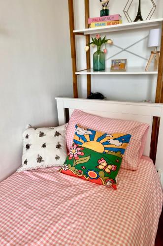 - un lit avec une couette rose et un oreiller dans l'établissement Paris centre Orsay studio, à Paris