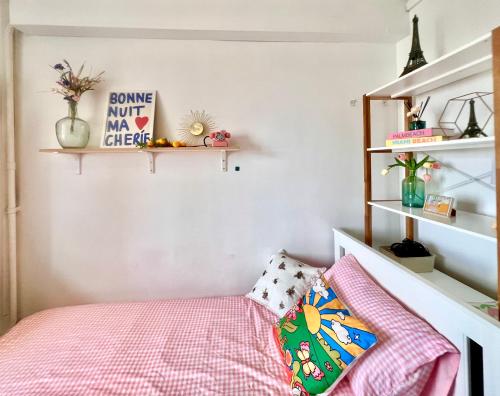 - une chambre avec un lit et des étagères roses dans l'établissement Paris centre Orsay studio, à Paris