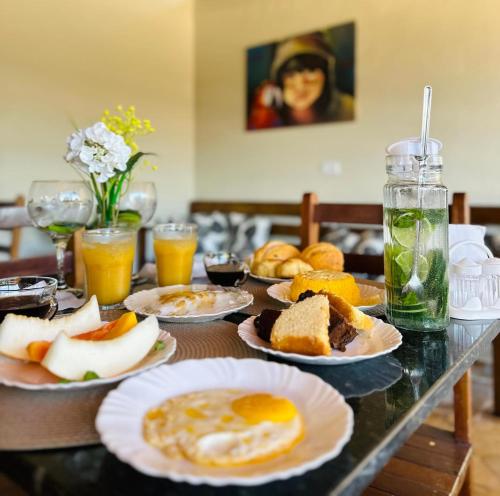 a table topped with plates of breakfast foods and drinks at Pousada Zoom Jericoacoara in Jericoacoara