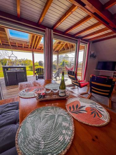 a dining room with a table with a bottle of wine at Chalet baie de La Forêt-Fouesnant in La Forêt-Fouesnant
