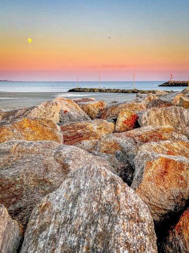a group of rocks on the beach at sunset at Chalet baie de La Forêt-Fouesnant in La Forêt-Fouesnant