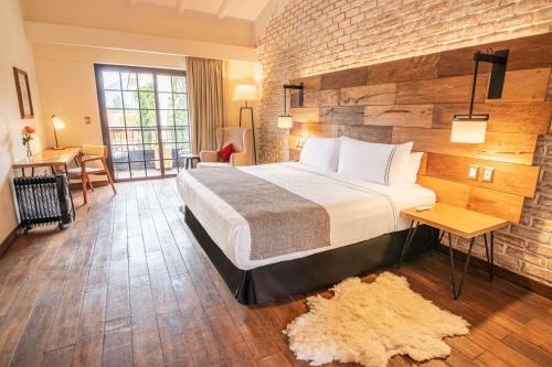 a hotel room with a bed and a brick wall at Sonesta Posadas del Inca - Valle Sagrado Yucay Urubamba in Urubamba