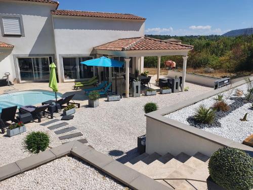 a backyard with a swimming pool and a house at BELLE VILLA 8 à 10 personnes parc du verdon in La Verdière