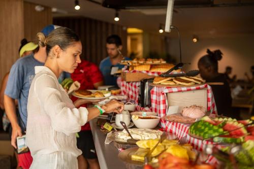 a woman is preparing food at a buffet at Dreamer Beach Club in San Andrés