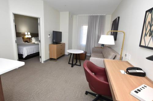 a hotel room with a couch and a bed and a desk at Staybridge Suites Detroit-Novi by IHG in Novi