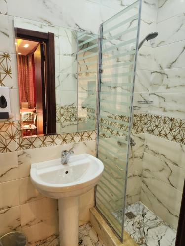 a bathroom with a sink and a glass shower at HOTEl Mansoura University Private in Mansoura