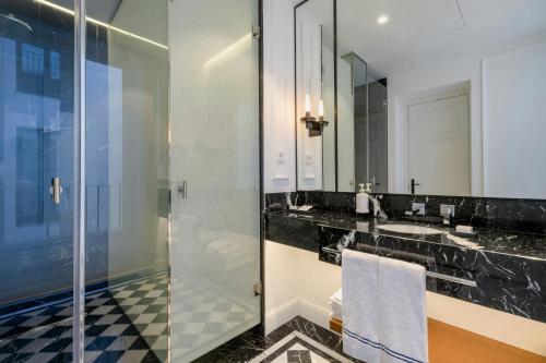 a bathroom with a glass shower and a sink at El Autor Hotel, Madrid, Autograph Collection in Madrid