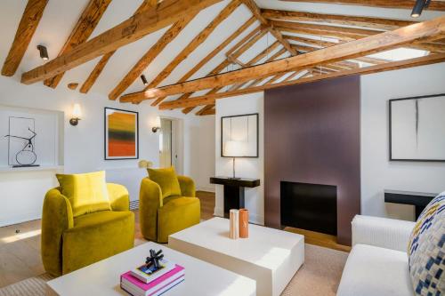 a living room with yellow chairs and a fireplace at El Autor Hotel, Madrid, Autograph Collection in Madrid