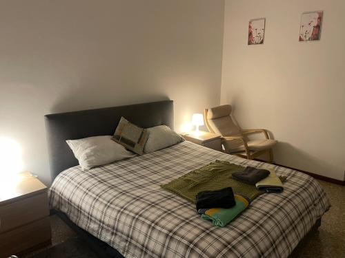 a bedroom with a bed with a plaid blanket and a chair at Private and quiet room in Rome