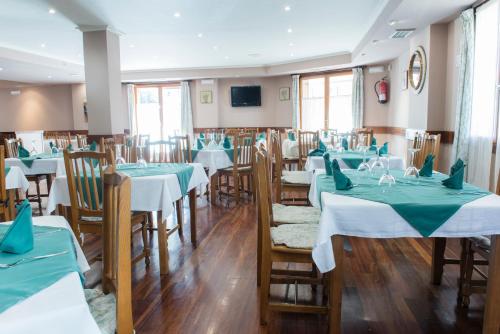 a restaurant with tables and chairs with green and white tablecloths at Hotel Alameda in Zarautz