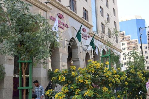 a building with flags and flowers in front of it at Crowne Plaza Madinah by IHG in Al Madinah