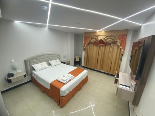 a bedroom with a bed and a window with a curtain at BRITNEY HOTEL Machala in Machala