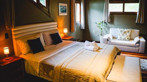 a bedroom with a large bed and a chair at Parque Nacional EcoResort in Urubici