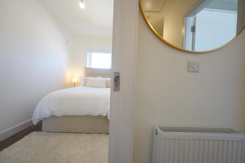 a bedroom with a bed with a mirror on the wall at The Dublin Luxe in Newcastle