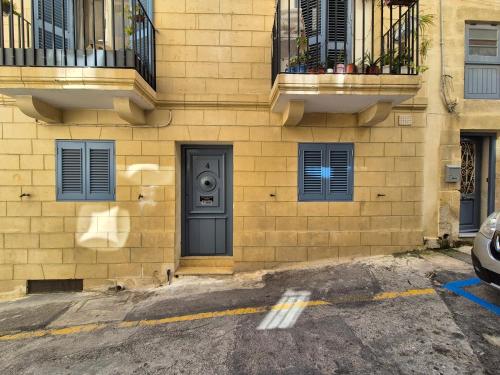 a yellow brick building with a door and windows at 3BR Family Stay Near Valletta in Hamrun