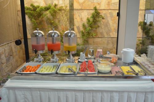 a buffet of food on a table with two juicer at Annamar Hotel in João Pessoa