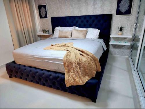 Una cama con cabecera azul en un dormitorio. en Atlantic Breeze House, en Cabrera