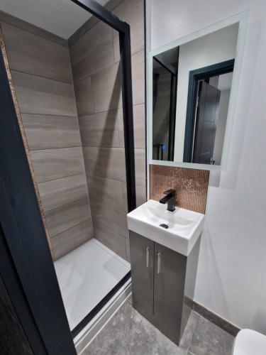 une petite salle de bain avec un lavabo et une douche dans l'établissement Stylish 3 bed 3 ensuites house with parking & garden, à Reading
