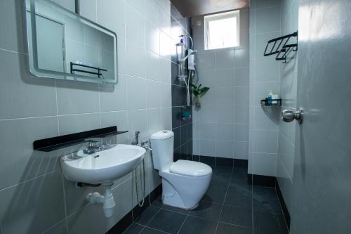 a white bathroom with a toilet and a sink at The Arts Smart Home Terengganu in Kuala Terengganu