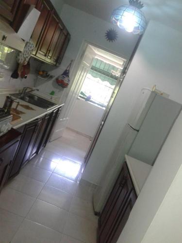 a kitchen with a white refrigerator and a sink at Posada Dilia del Alba in Santo Domingo