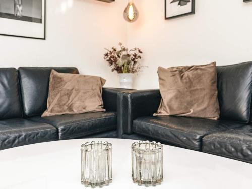a living room with two black leather couches at 8 person holiday home in Bagenkop-By Traum in Bagenkop