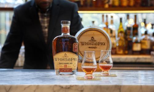 a bottle of whiskey and two glasses on a counter at Crowne Plaza Atlanta Perimeter at Ravinia by IHG in Atlanta