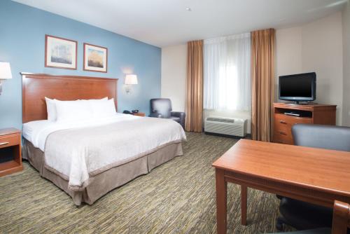 a hotel room with a large bed and a desk at Candlewood Suites Wake Forest-Raleigh Area by IHG in Wake Forest