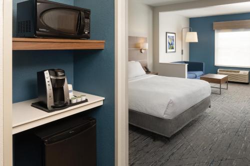 a hotel room with a bed and a tv at Holiday Inn Express & Suites Orlando International Airport by IHG in Orlando