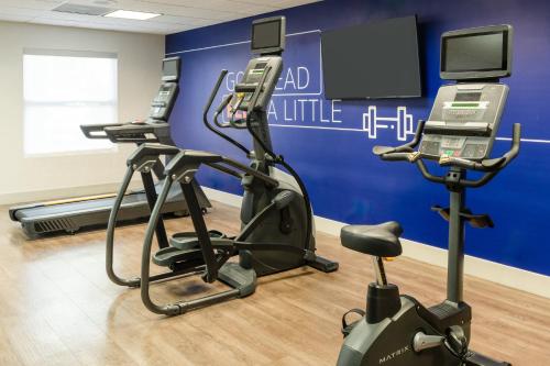 a gym with two exercise bikes and a tv at Holiday Inn Express & Suites Orlando International Airport by IHG in Orlando
