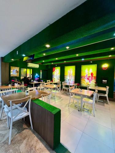 Un restaurante con mesas y sillas de madera y paredes verdes. en Hotel Jazuli, en San José del Cabo