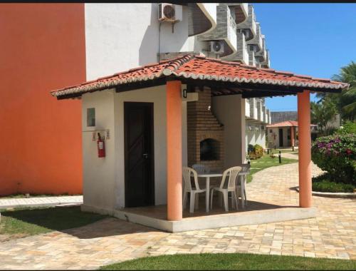 a gazebo with chairs and a table in a building at Ocean view apart inteiro lazer privativa in Nísia Floresta