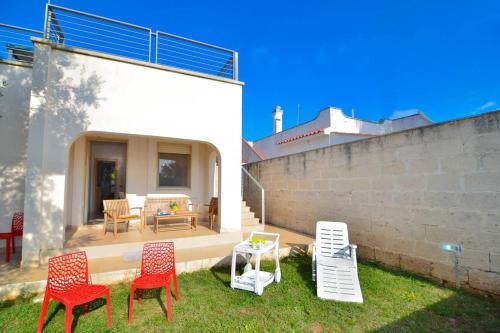 a yard with chairs and a table and a patio at Boomerang Village in Torre Colimena