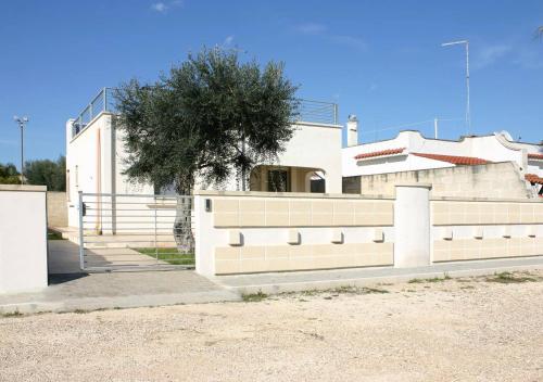 a white house with a tree in front of it at Boomerang Village in Torre Colimena